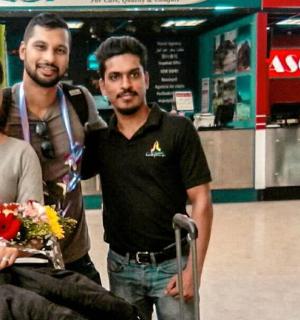 three men standing next to a woman in an airport