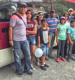 a group of people standing in front of a bus