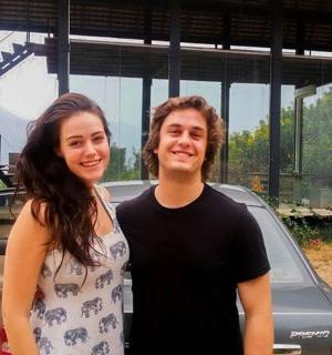 一名男子和一名女子站在一辆汽车旁边