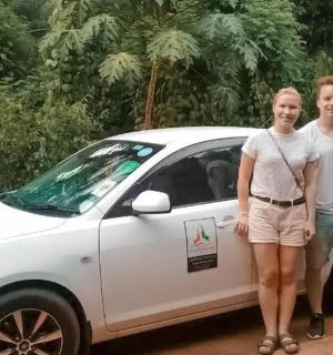 two people standing in front of a white car