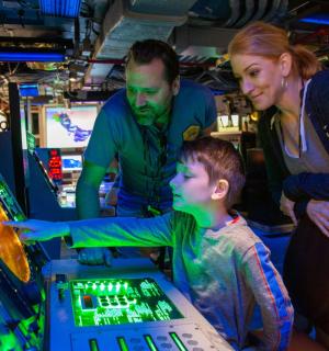 dva dospělí a dítě hrající videohru