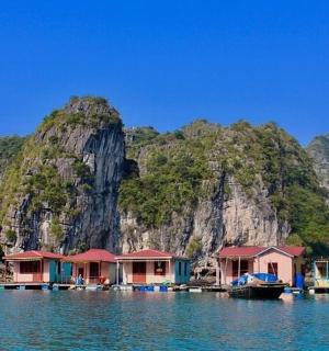 a group of houses in the water near a mountain
