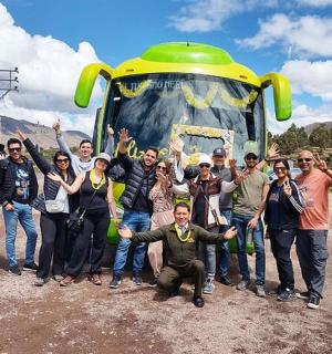 a group of people standing in front of a bus