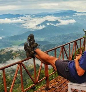 一名男子坐在山顶的椅子上
