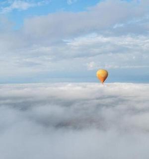 a hot air balloon flying above the clouds