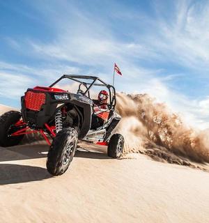 一个人在沙地上骑着四轮车