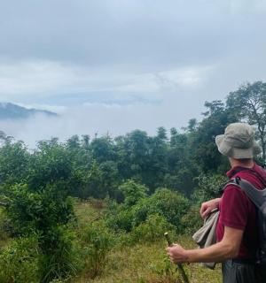 a man with a backpack looking out over a forest