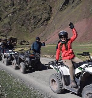skupina lidí jedoucích na čtyřkolkách po horské silnici