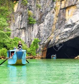 一名男子正在山洞前划船