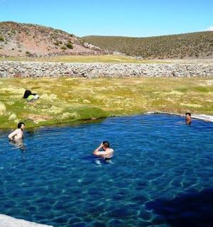 三个人在蓝色的池水中游泳