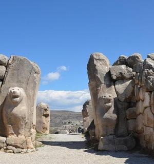 a stone wall with statues of faces on it