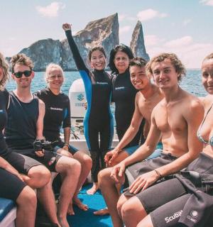 eine Gruppe von Menschen sitzt auf einem Boot im Wasser