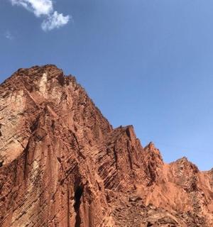 a brown mountain in front of a blue sky