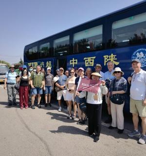 a group of people standing in front of a bus