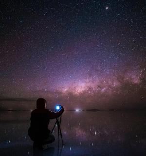 a person taking a picture of the night sky