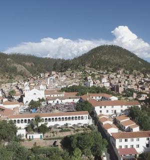 a town on a hill with mountains in the background