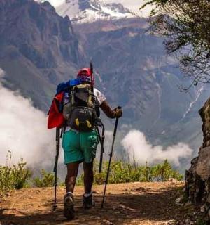 一名背着背包的男子站在山路上