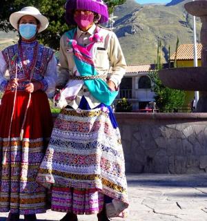 两名戴着面具的女子站在喷泉前