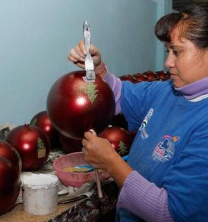 a woman is standing next to a pile of red apples