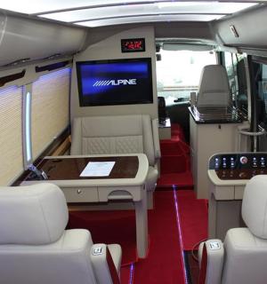 an interior of a bus with two chairs and a tv