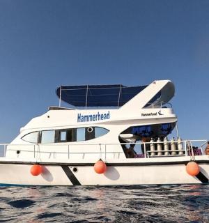 a white boat in the water with people on it