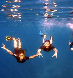 a group of three people swimming in the water