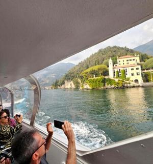 un gruppo di persone che scatta foto di una barca su un lago