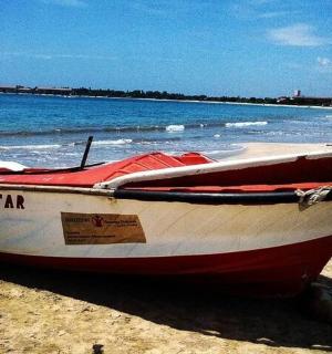a red and white boat sitting on the beach
