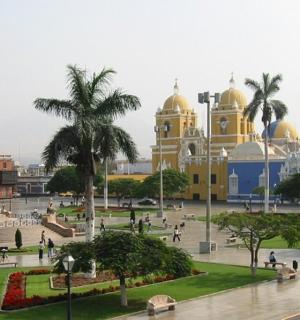 Velká žlutá budova s lidmi v parku