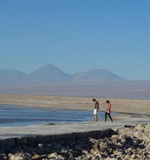 two people walking on a beach in the desert