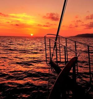 a boat in the ocean with a sunset in the background