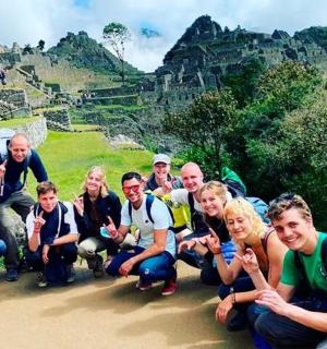 a group of people posing for a picture at the ruins