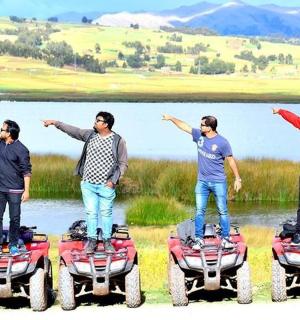 a group of men standing on the back of four atvs