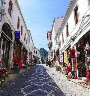 eine gepflasterte Straße in einer Altstadt mit Geschäften