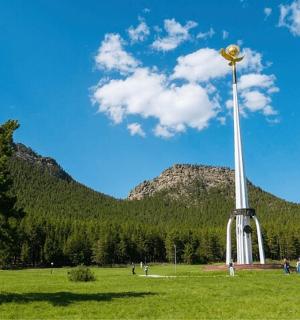 a pole in a field with mountains in the background