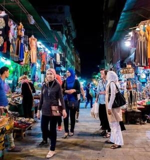 skupina lidí procházejících se v noci trhem