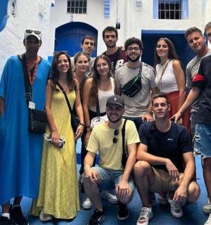 a group of people posing for a picture in front of a building