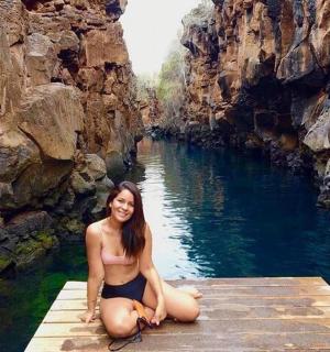 一位女士坐在河边的码头上