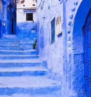 一条有楼梯和蓝色门的蓝色小巷