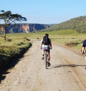 两个人骑着自行车沿着土路行驶