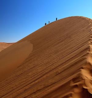 三个人站在沙丘顶上