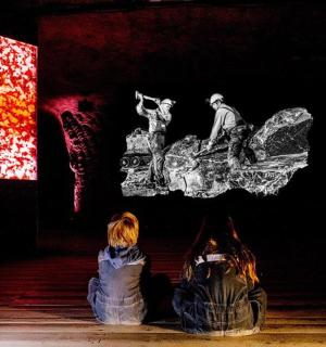 двоје људи седе на поду и гледају слику