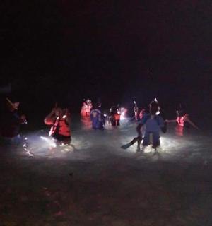 skupina lidí stojících ve tmě