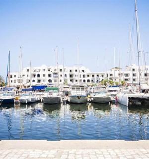 一群船停靠在码头，码头上有一座建筑