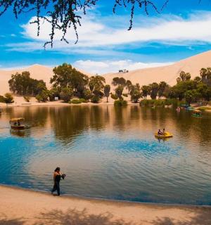 a person standing in the water in front of a lake