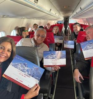 一群人坐在飞机上,手里拿着证书