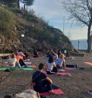 a group of people sitting on a beach doing yoga