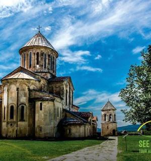 an old church with a tower on a green field
