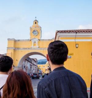 a group of people looking at a building with a clock tower
