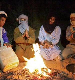 a group of people sitting around a fire